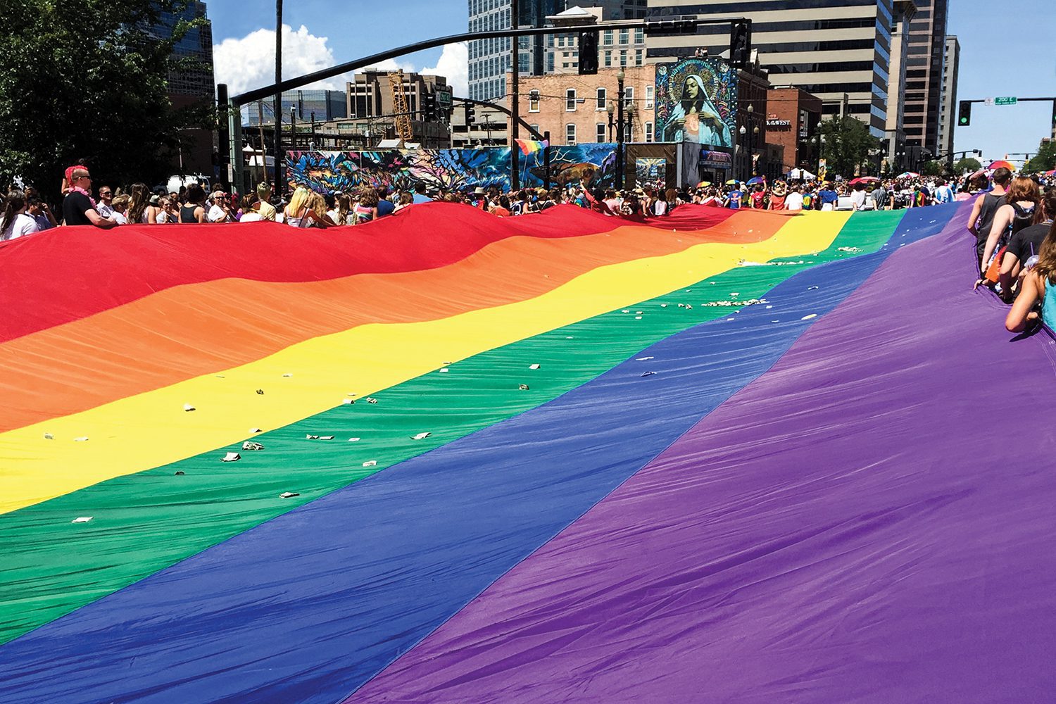 Utah Pride Parade participants with rainbow flag.