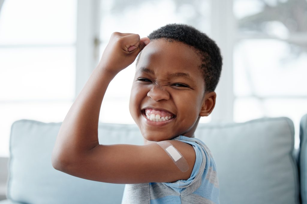 boy kid, vaccine and portrait with smile, medicine and flex muscle for wellness in hospital. Male child, strong and excited with plaster for injection, healthcare and injection to stop virus. vaccine recommendations