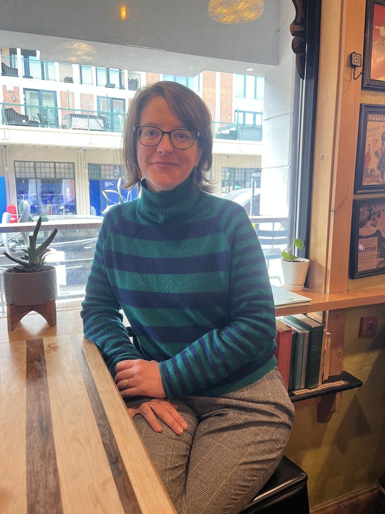 Filmmaker Kat Whalen poses in a teal striped sweater in Park City, Utah. 