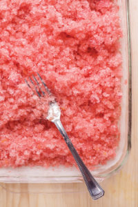 The making of a refreshing watermelon granita with ginger and strawberry.  A delicious homemade Italian dessert for hot summer days.