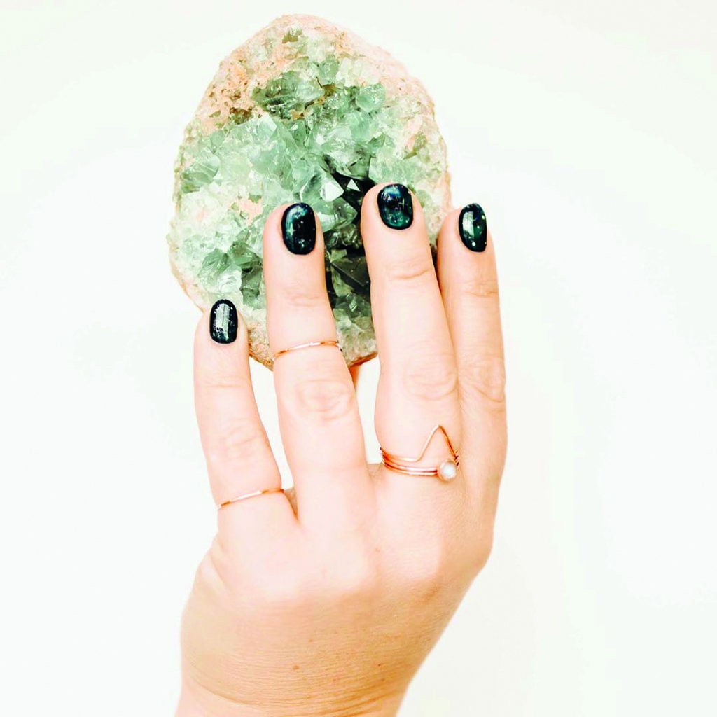 Hand manicured with black polish from Nova Nails holds a crystal