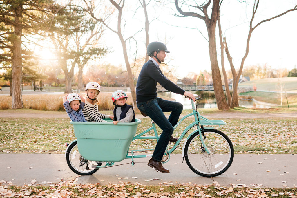 Family in nutcase helmets rides a bucket bike